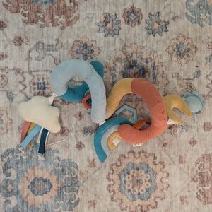 Itzy Ritzy Rainbow Stroller Toy - Teal, Rust, Mustard